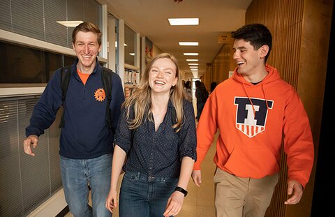 Three students walk down the hall in the Education Building.