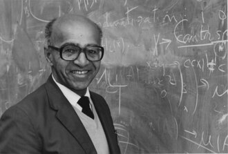 Picture of David H. Blackwell in front of a chalk board