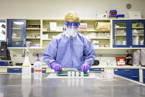 Male undergraduate working in lab using PPE