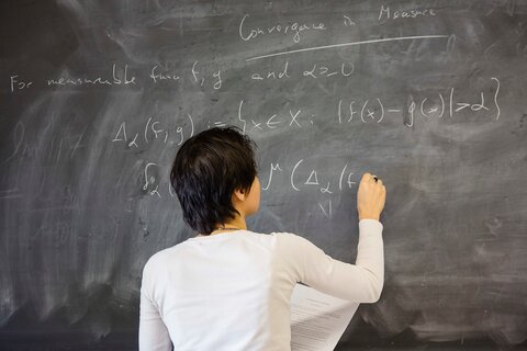 Female professor teaching math to students in Altgeld Hall.