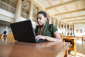 Student studying in library on laptop