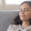 RIO program woman with headphones on couch