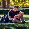 Student stuydying on grass. The University of Illinois quad and a beautiful day make for a perfect place to study outside.